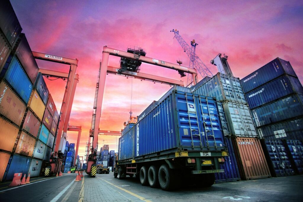Gestapelte Schiffscontainer in einem Hafen bei Sonnenuntergang als Symbol für den Export